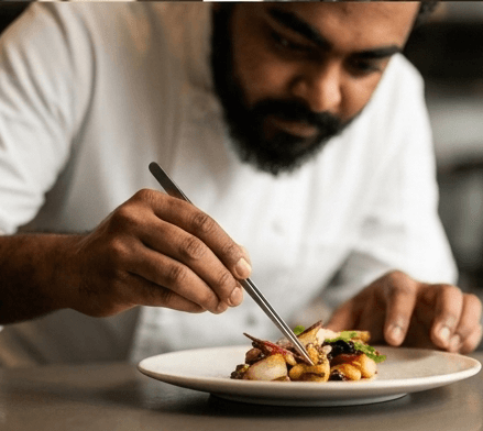 Chef Nirmal Ranganathan plating a dish with precision